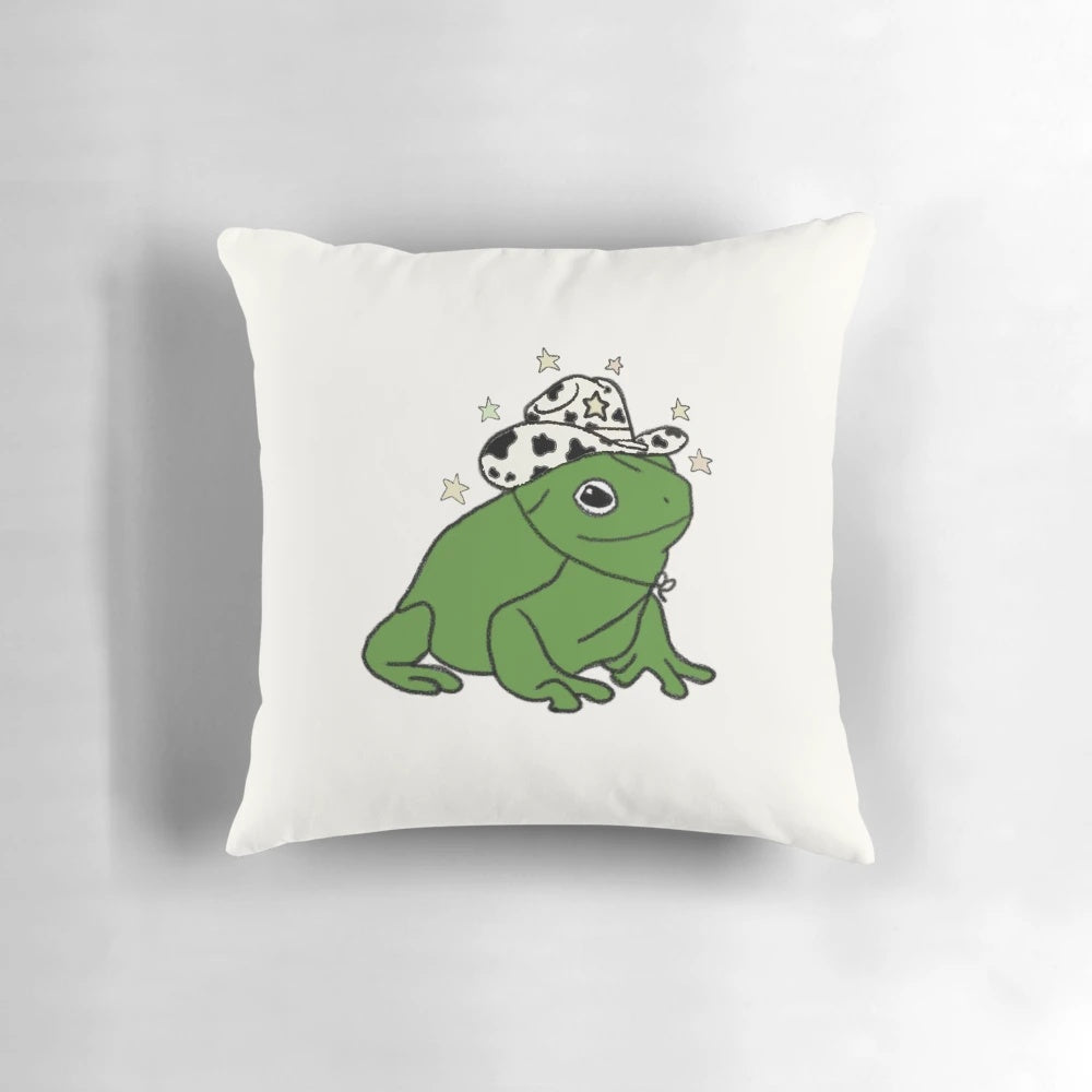 A soft and whimsical pillow featuring a frog wearing a cowboy hat, perfect for adding a touch of rustic charm to any space.