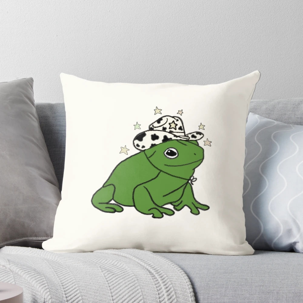 A soft and whimsical pillow featuring a frog wearing a cowboy hat, perfect for adding a touch of rustic charm to any space.