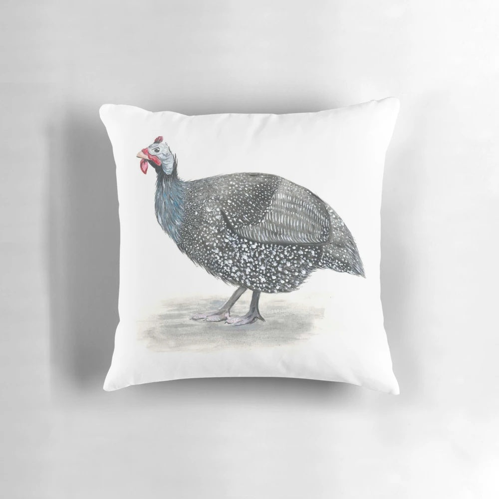 Close-up of a decorative guinea fowl-themed throw pillow with a painted bird design