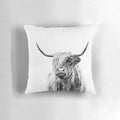 A cozy pillow featuring a portrait of a fluffy, horned highland cow against a warm, rustic backdrop.