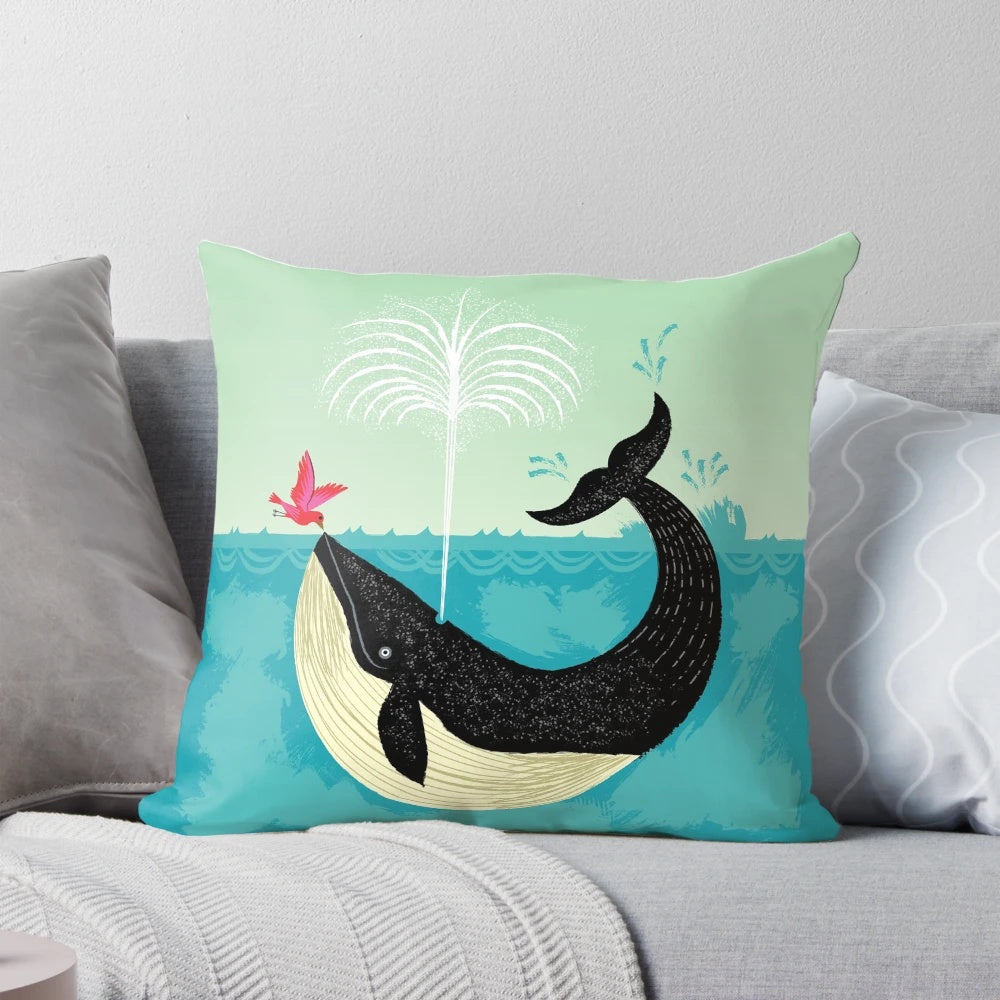 Decorative pillow featuring a whimsical illustration of a whale and bird in a coastal scene