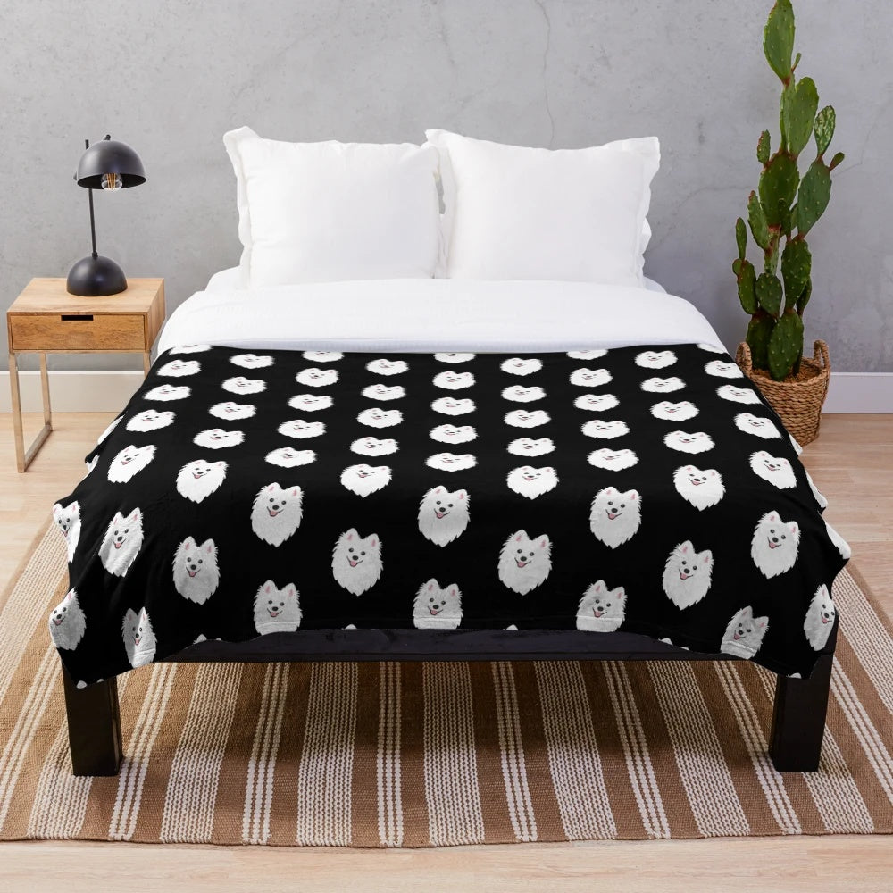 Curious white spitz puppy dog on charcoal black plush blanket