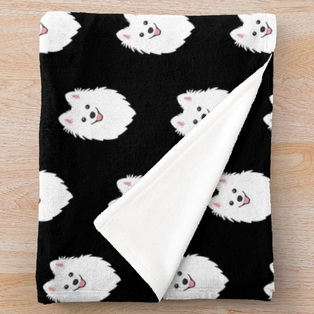 Curious white spitz puppy dog on charcoal black plush blanket