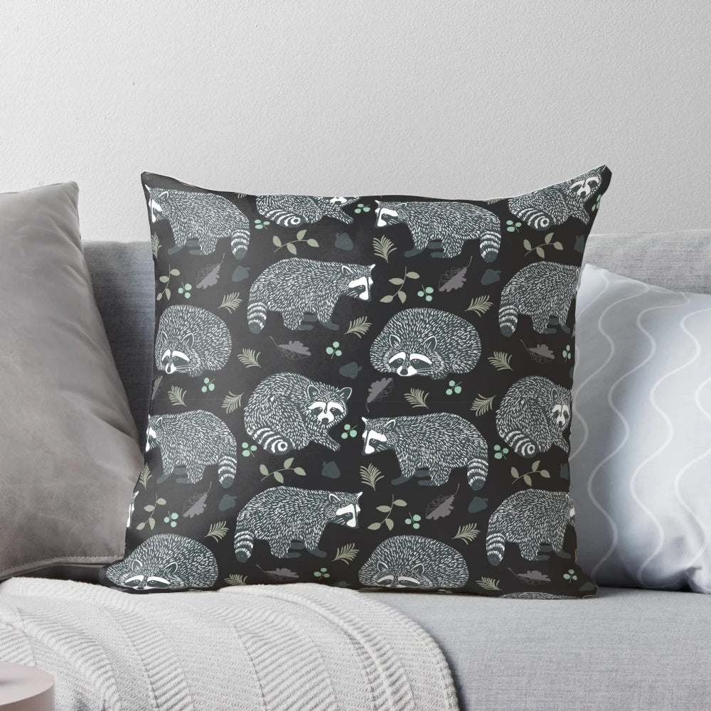 Decorative throw pillow with a whimsical repeat pattern of cute raccoons in a woodland setting