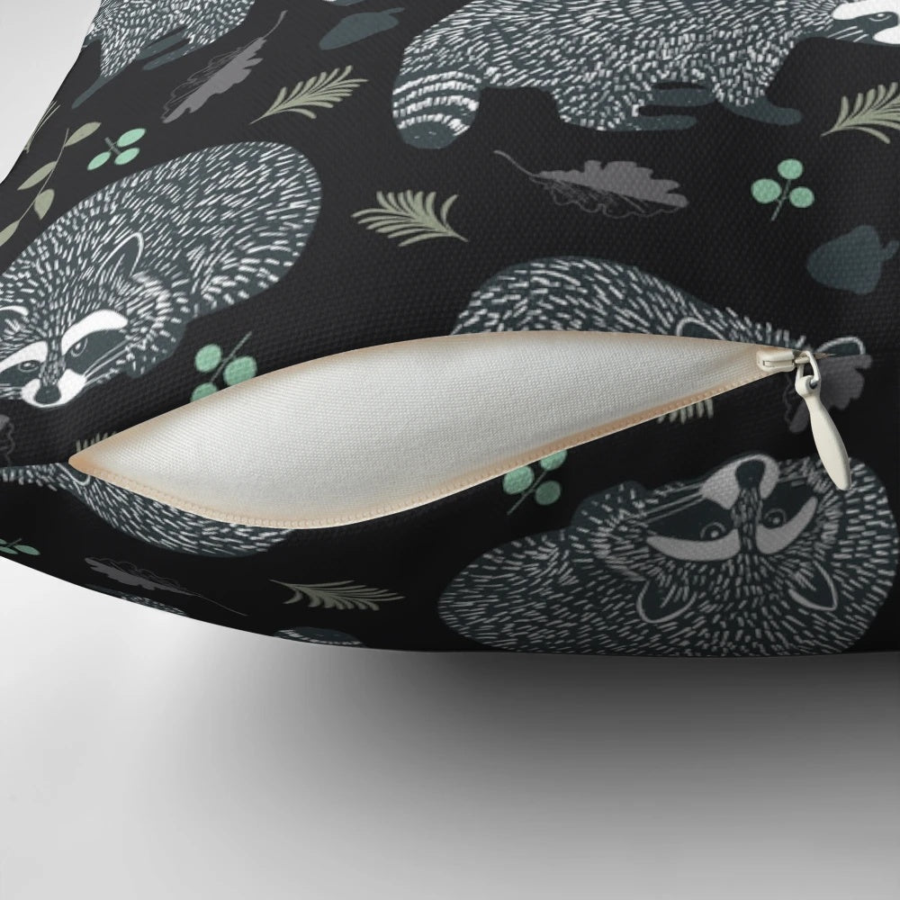 Decorative throw pillow with a whimsical repeat pattern of cute raccoons in a woodland setting