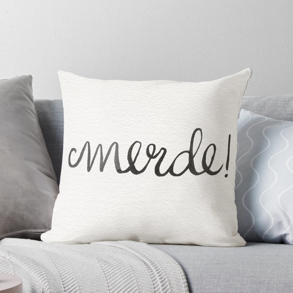 Merde!" decorative pillow with watercolor, gouache, and ink French curse word art in navy, gold, and blue tones.
