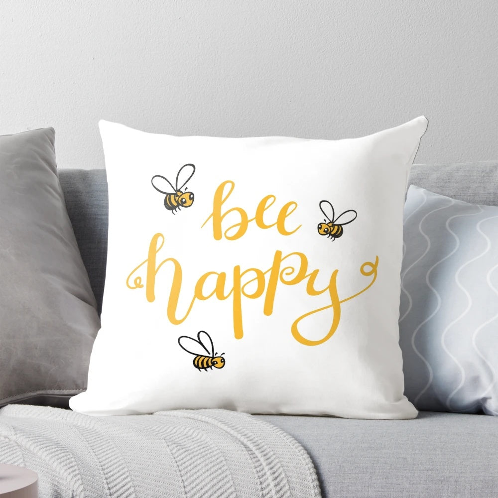 Bright yellow bee-themed pillow with "Bee Happy" lettering