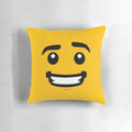 A bright yellow pillow featuring a smiling lego-style face design