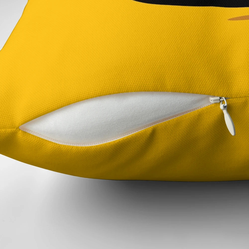 A bright yellow pillow featuring a smiling lego-style face design