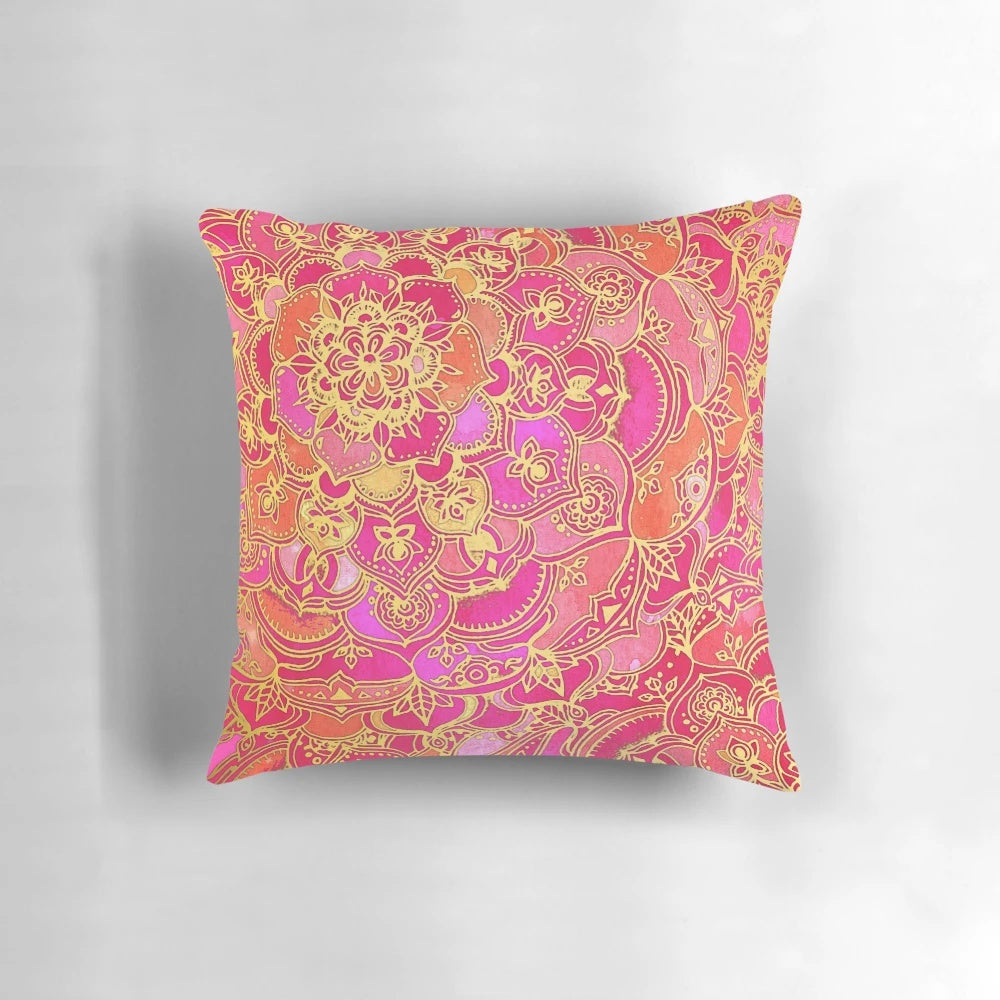 Close-up of a hot pink and gold baroque floral pattern pillow with a mandala-inspired design.