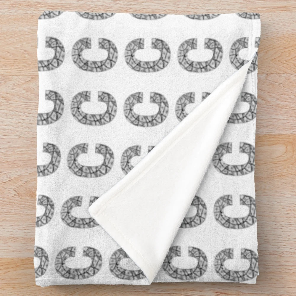 Plush black and white blanket with stylized letter C design