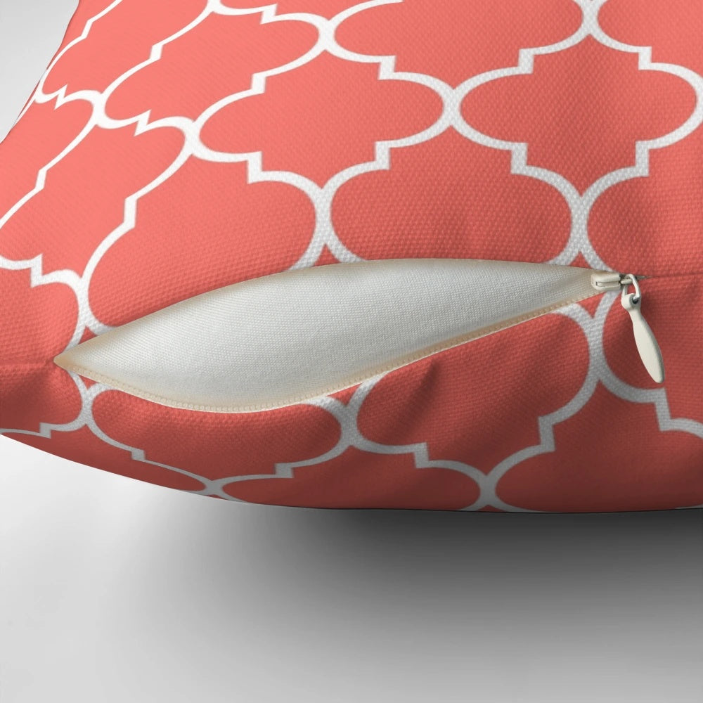 A plush, living coral quatrefoil-patterned pillow with a modern, elegant design.
