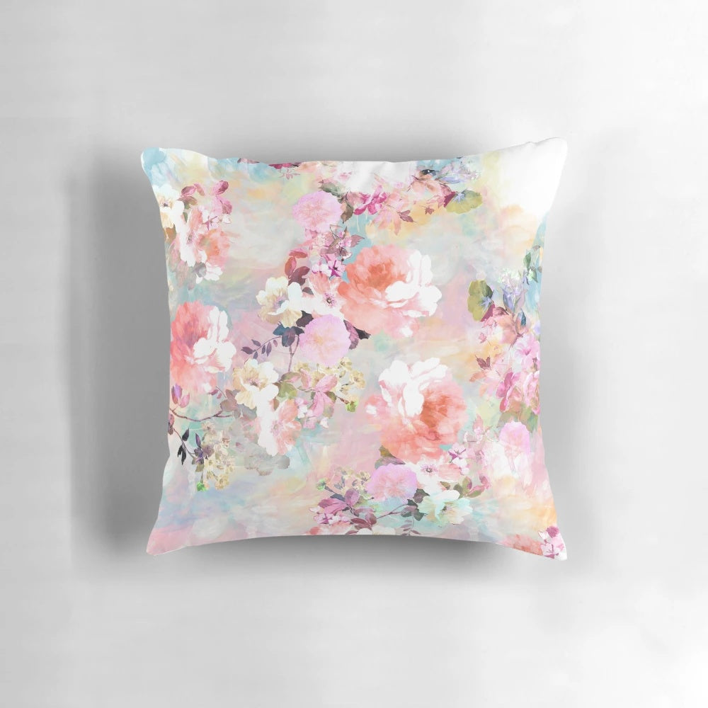 A pink and teal watercolor floral pattern on a plush, chic throw pillow.