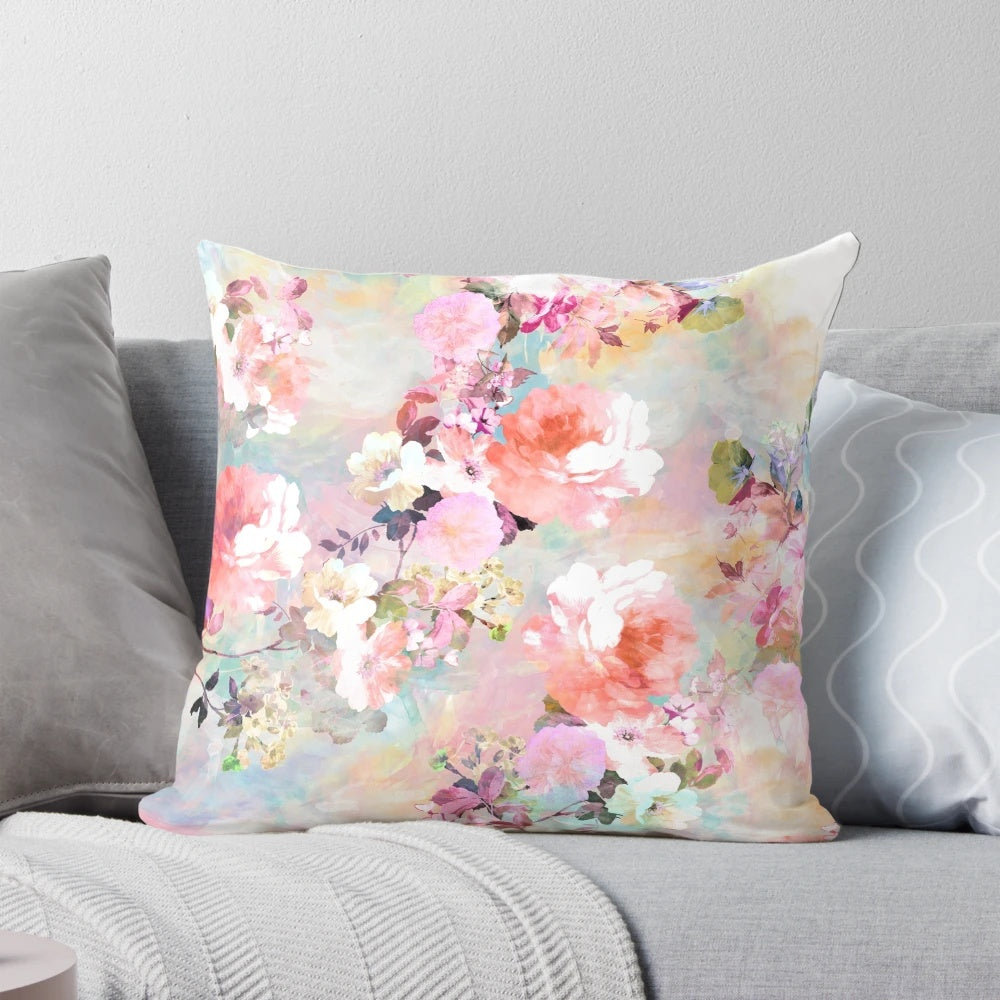 A pink and teal watercolor floral pattern on a plush, chic throw pillow.