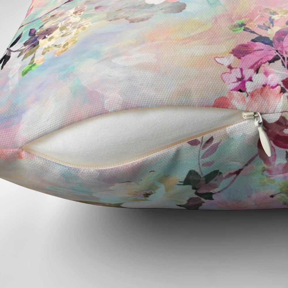 A pink and teal watercolor floral pattern on a plush, chic throw pillow.