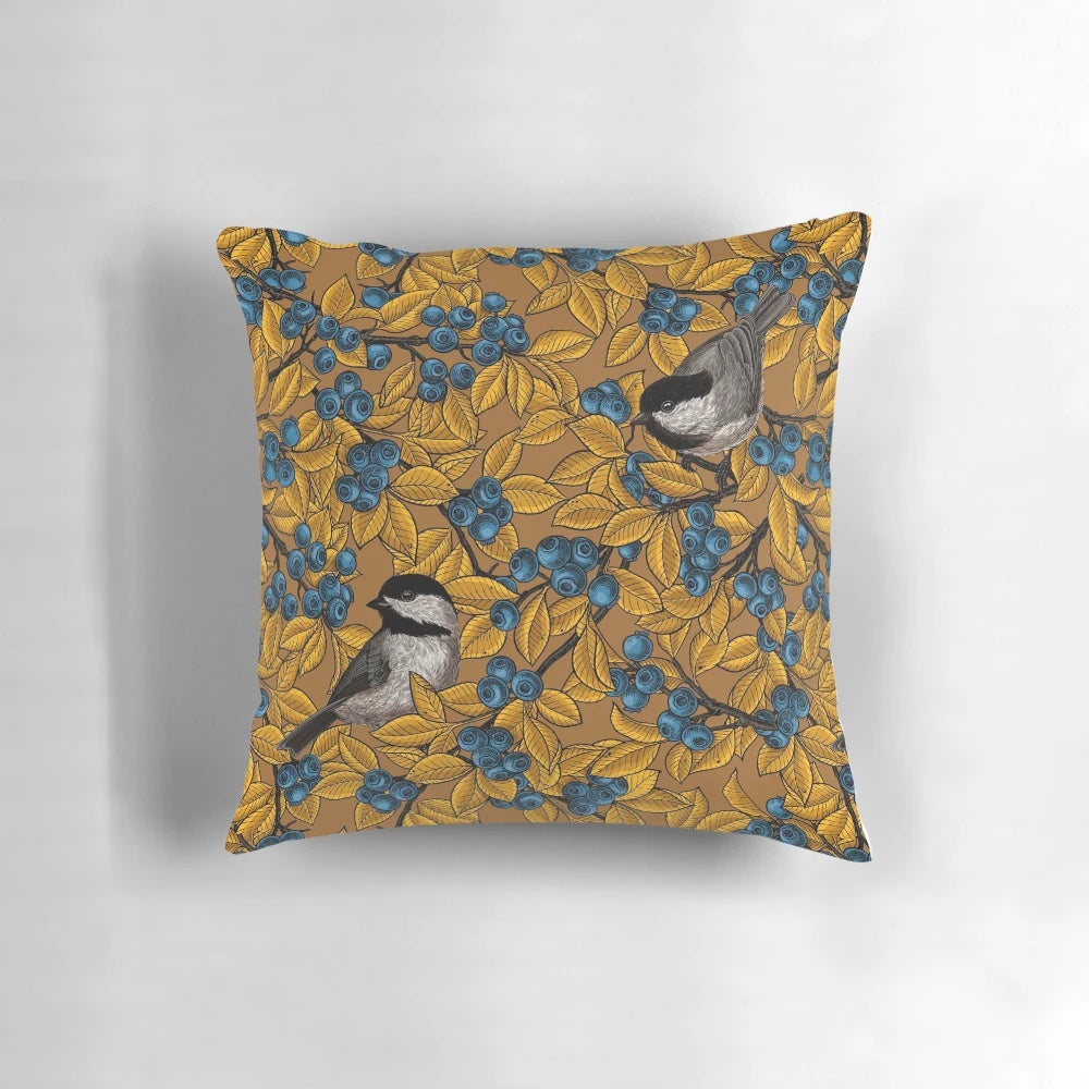 Decorative throw pillow featuring a pattern of chickadee birds perched on blueberry branches.