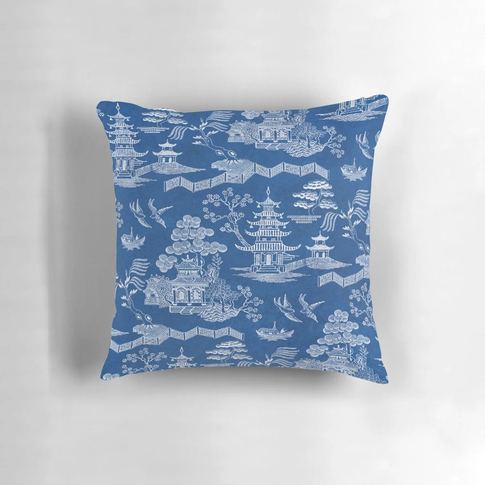 Chinoiserie-style blue and white decorative pillow with pagoda, crane, and boat motif