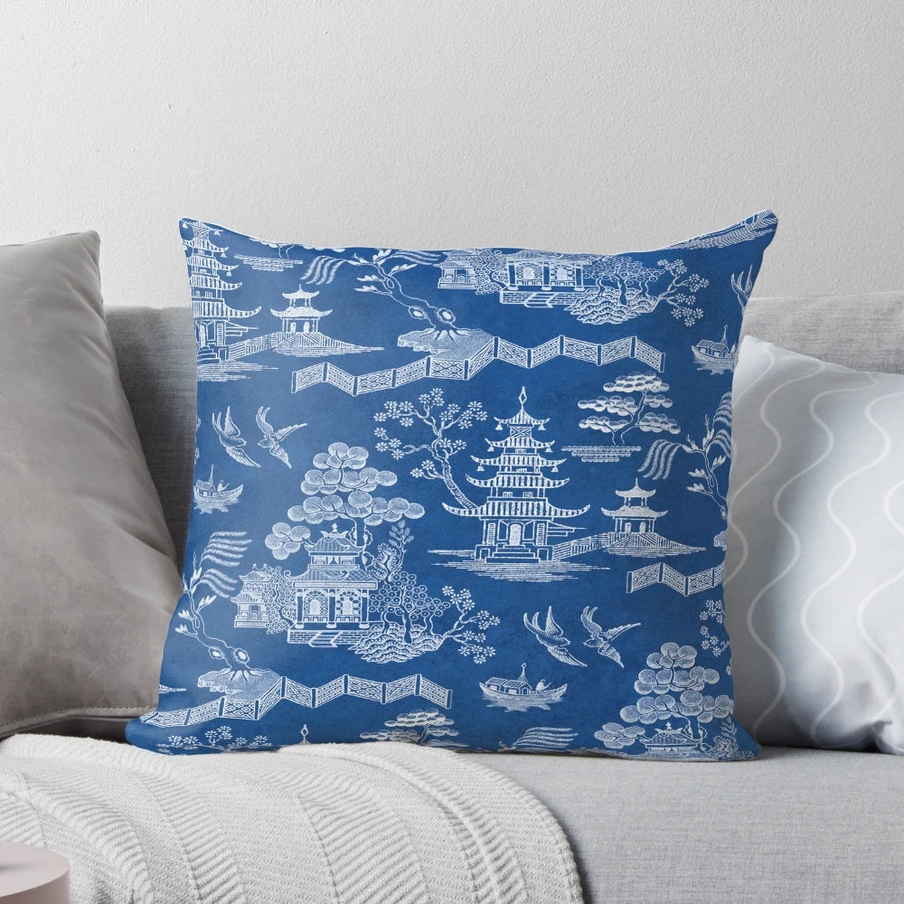Chinoiserie-style blue and white decorative pillow with pagoda, crane, and boat motif