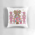 A pink and blue chinoiserie-style Christmas nutcracker pillow with a glittering tree and holiday bow accents.