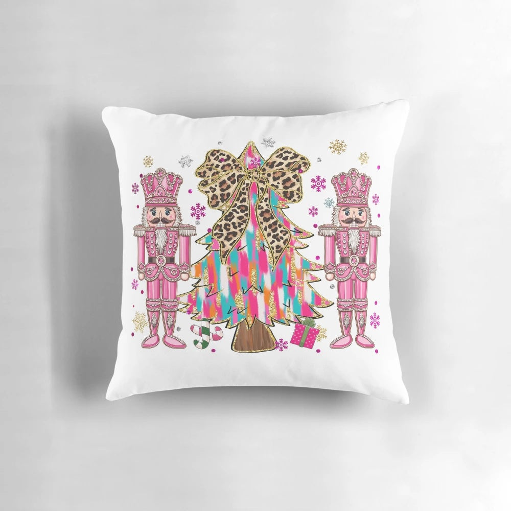 A pink and blue chinoiserie-style Christmas nutcracker pillow with a glittering tree and holiday bow accents.