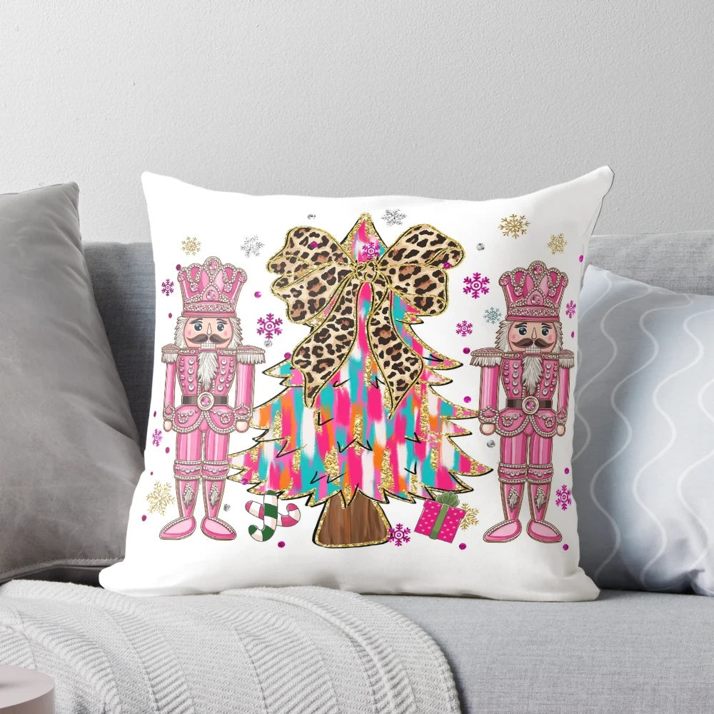 A pink and blue chinoiserie-style Christmas nutcracker pillow with a glittering tree and holiday bow accents.