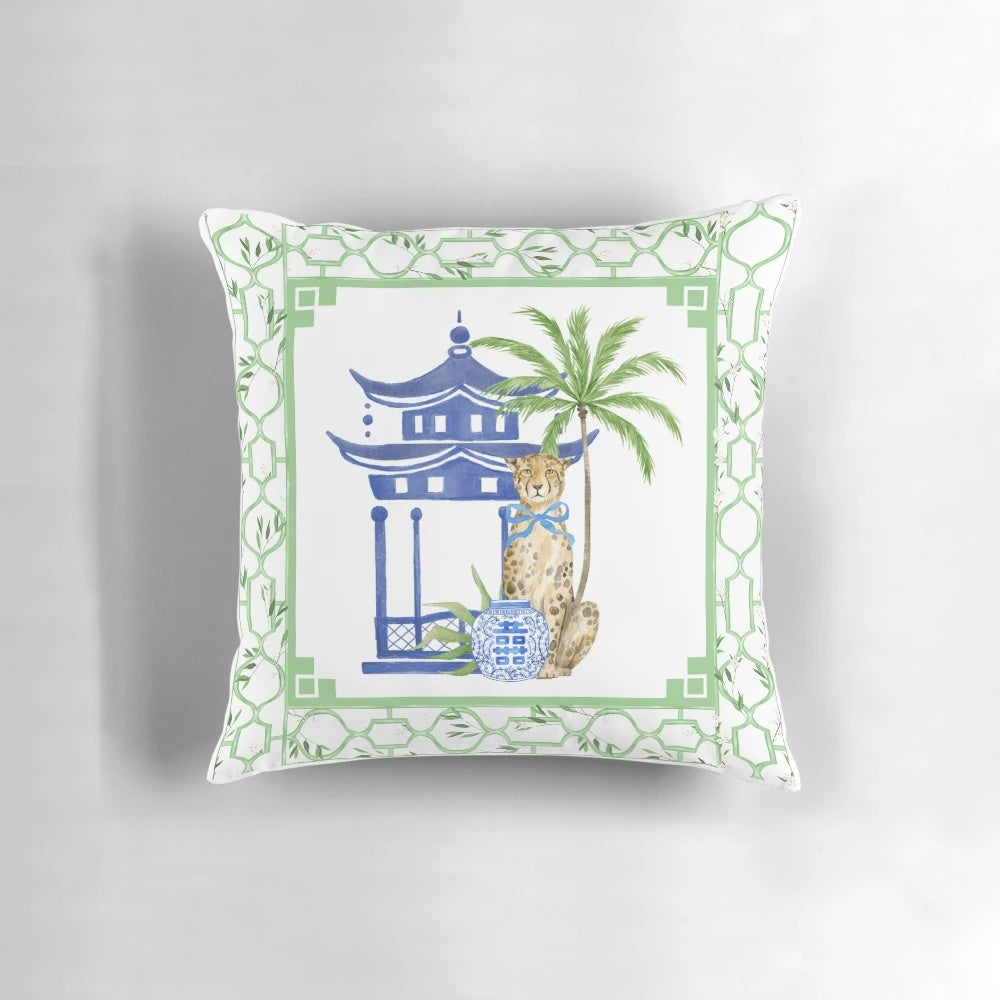 Chinoiserie-style pillow with pagoda, palm tree, and leopard print design in blue and white color scheme