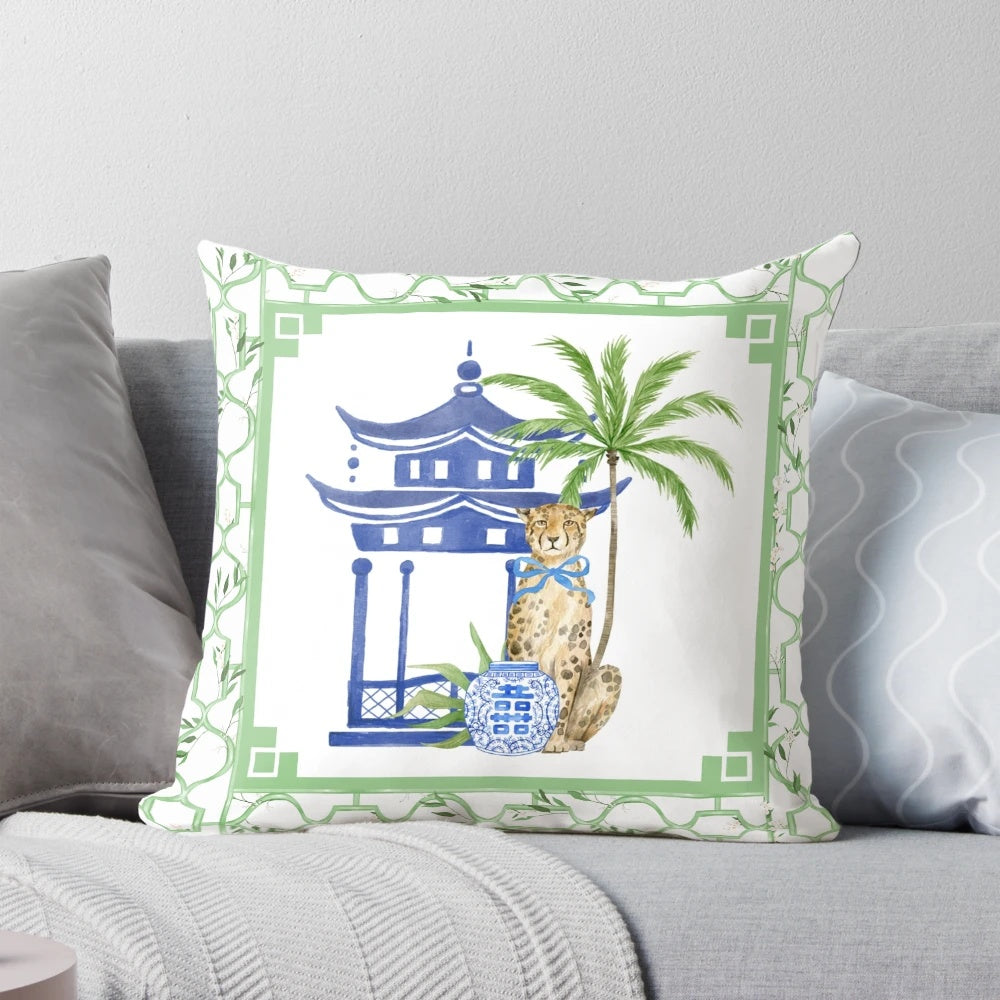 Chinoiserie-style pillow with pagoda, palm tree, and leopard print design in blue and white color scheme