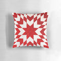 Close-up of a beautiful handmade red and white patchwork quilt pillow with a traditional lone star pattern.