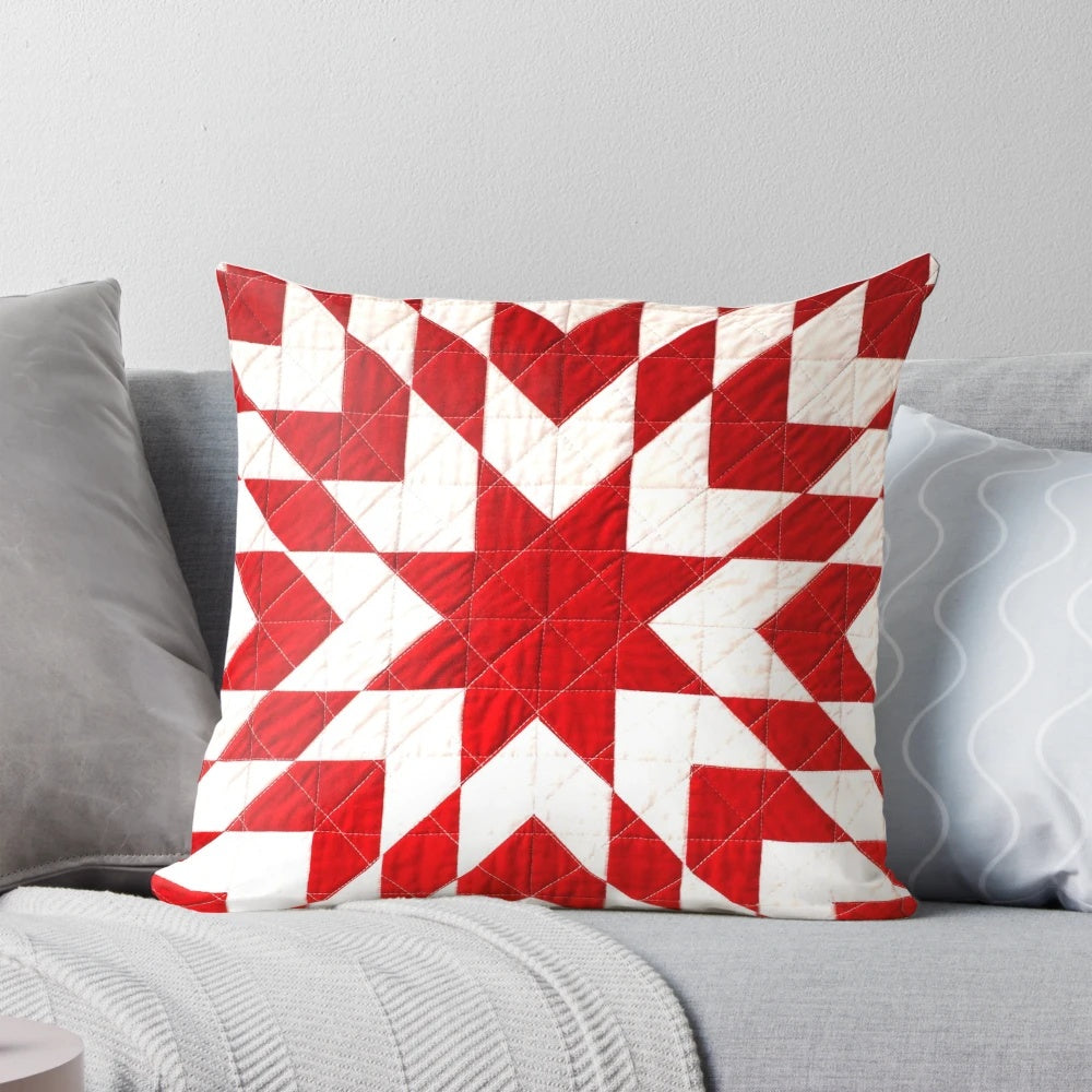 Close-up of a beautiful handmade red and white patchwork quilt pillow with a traditional lone star pattern.