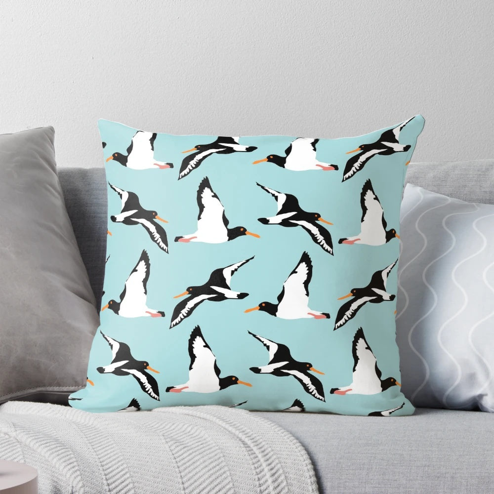 Oyster catcher pattern decorative pillow with black and white bird design on a blue background