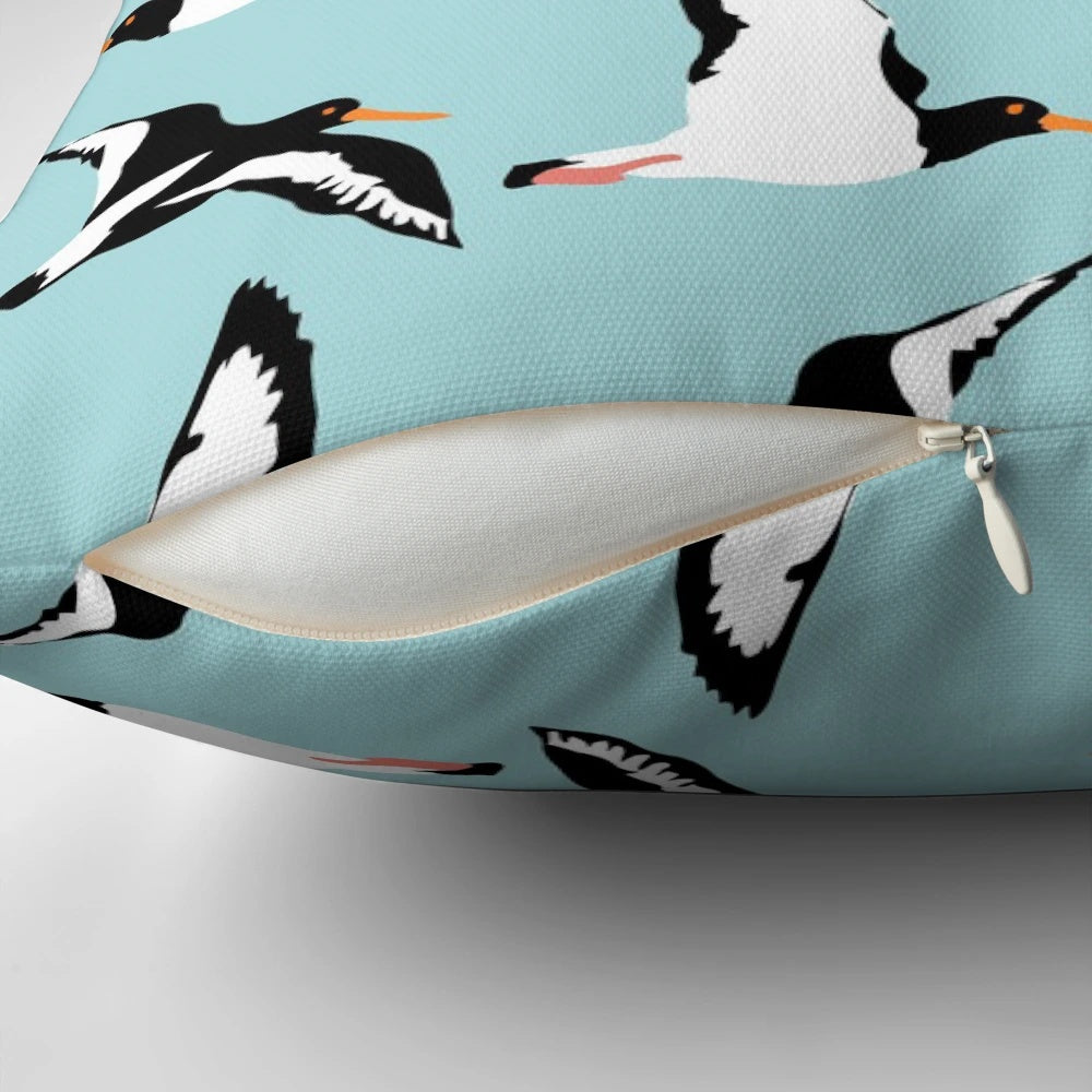 Oyster catcher pattern decorative pillow with black and white bird design on a blue background
