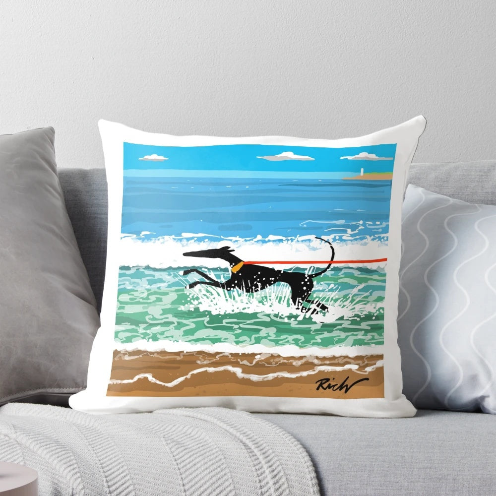 Image of a decorative pillow featuring a coastal landscape with greyhounds, whippets, and lurchers