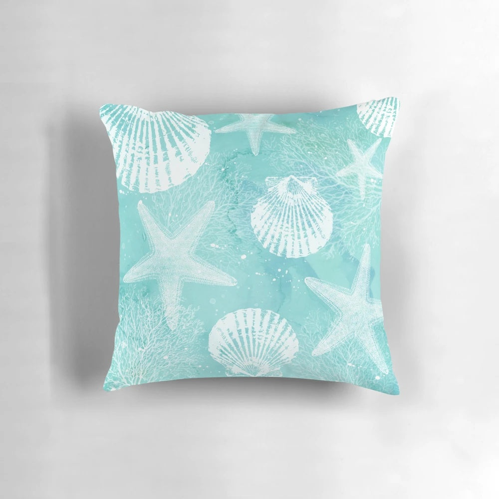 Coastal-inspired decorative pillow with starfish, seashells, and turquoise colors