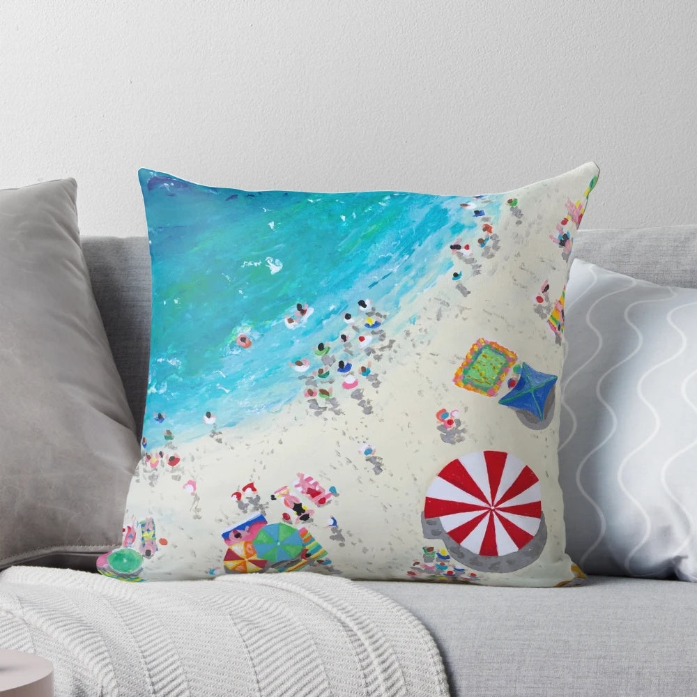 Coastal-inspired pillow featuring an aerial view of a beach and waves, designed by artist Stephanie Fuller