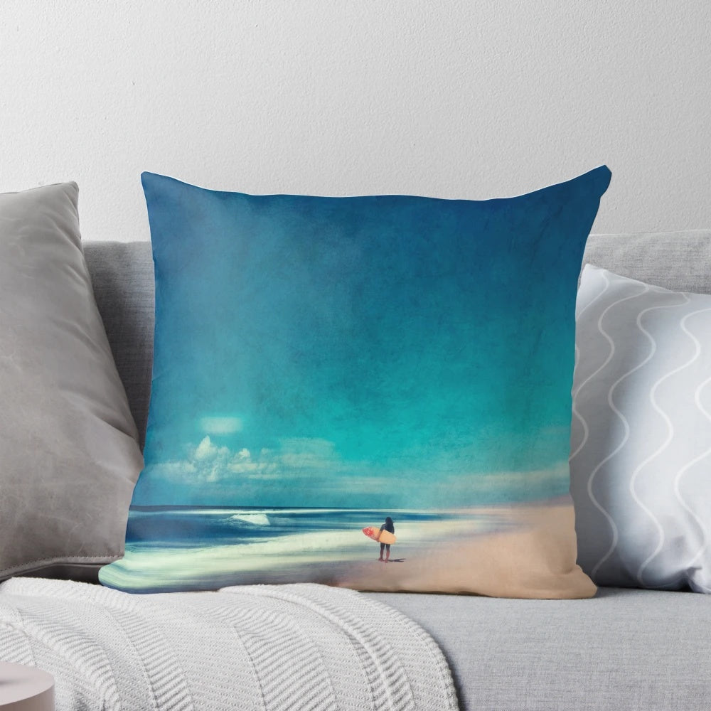 Colorful coastal art pillow depicting ocean waves, a surfer, and a teal and rose landscape for beach house decor.