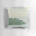 A decorative pillow featuring a design of shorebirds perched on rocky coastal landscape.