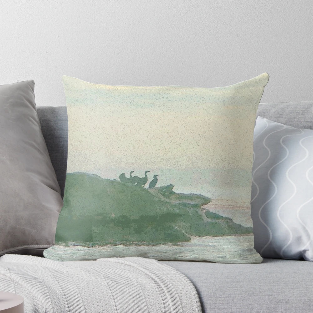 A decorative pillow featuring a design of shorebirds perched on rocky coastal landscape.