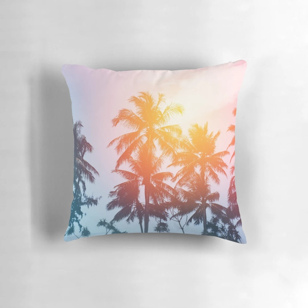 Coastal sunset pillow featuring a silhouette of palm trees against a colorful sky