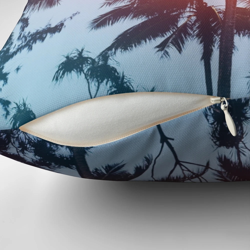 Coastal sunset pillow featuring a silhouette of palm trees against a colorful sky
