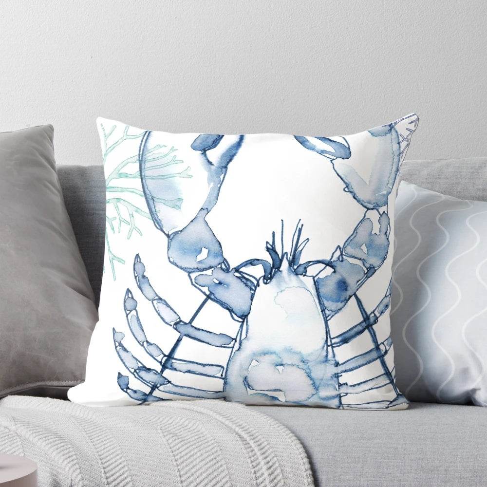 A watercolor painting of a coastal lobster in shades of blue and white, featured on a decorative throw pillow.