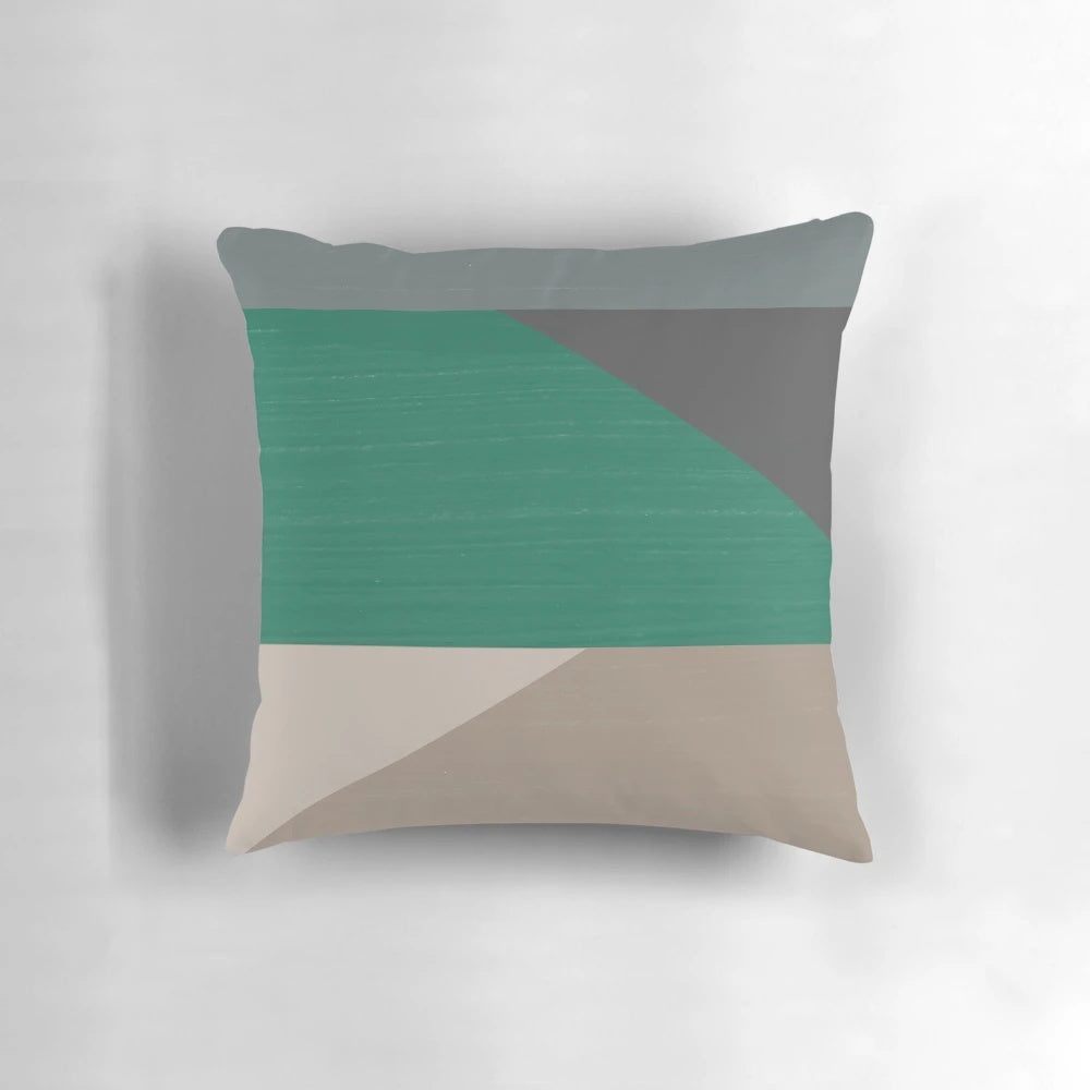 Colorblock pillow in earth tones of buff, cement, steel grey, charcoal, and emerald green