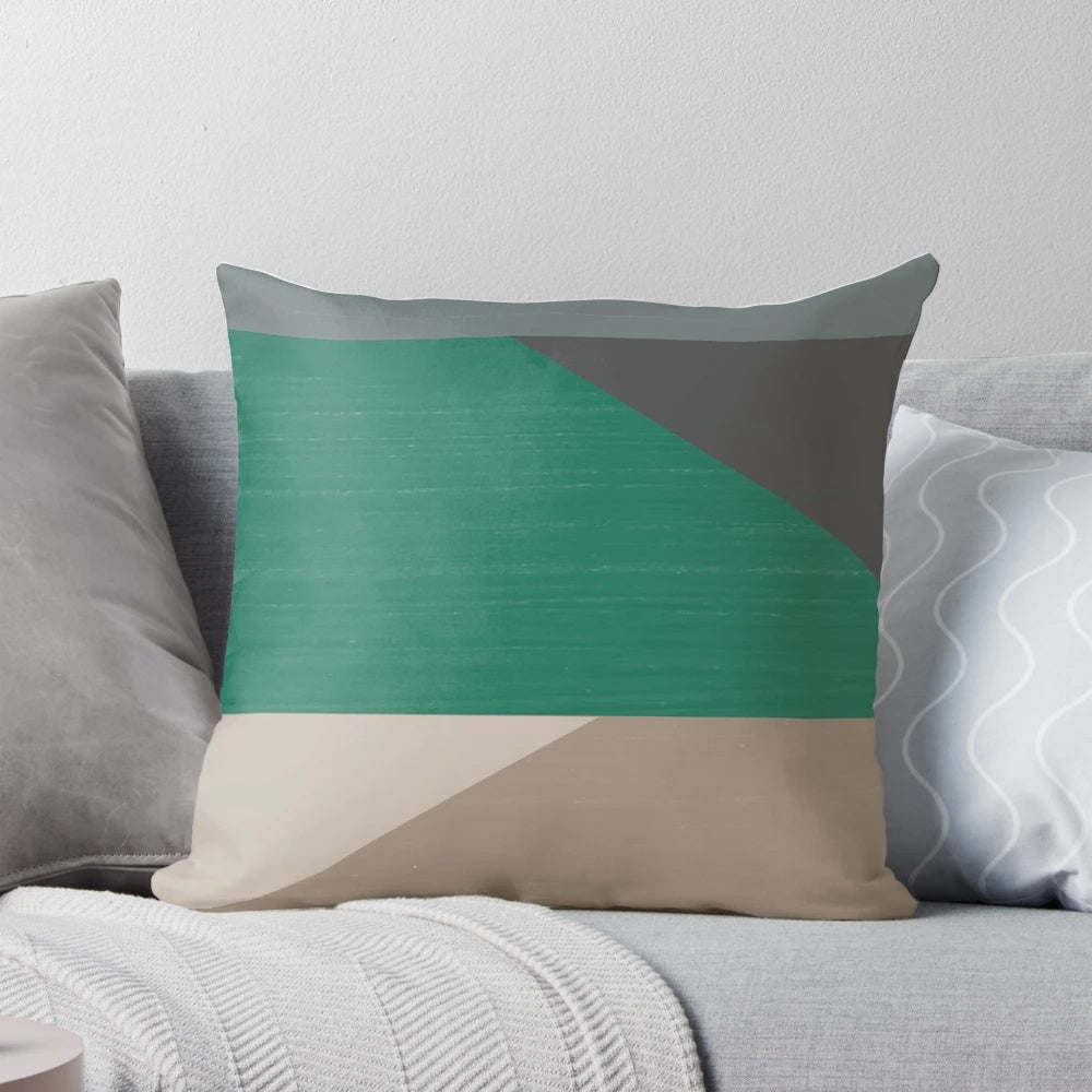 Colorblock pillow in earth tones of buff, cement, steel grey, charcoal, and emerald green