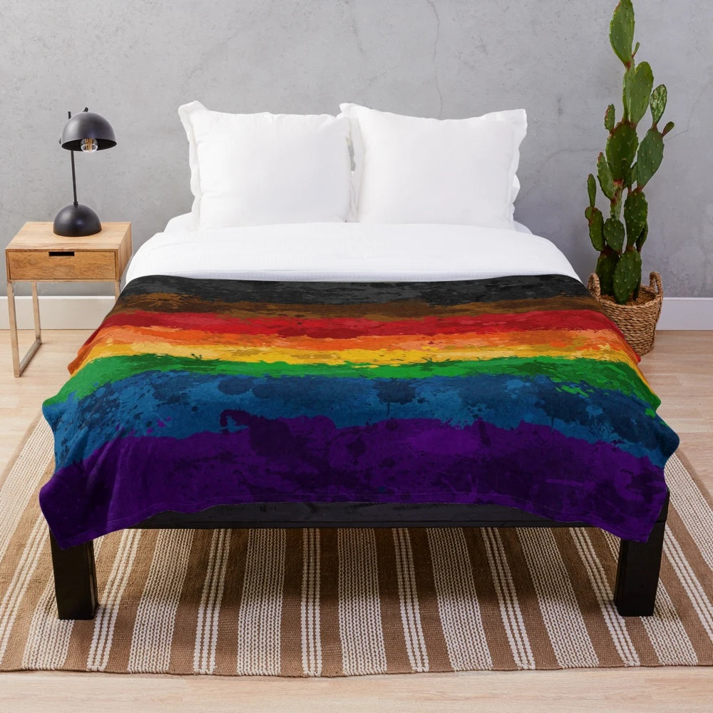 Colorful abstract paint splatter design on a plush, soft blanket with a rainbow pride flag motif