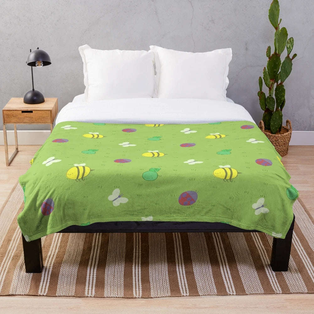 Colorful plush blanket featuring an adventure-inspired pattern with birds, bees, caterpillars, and other cute insects and critters