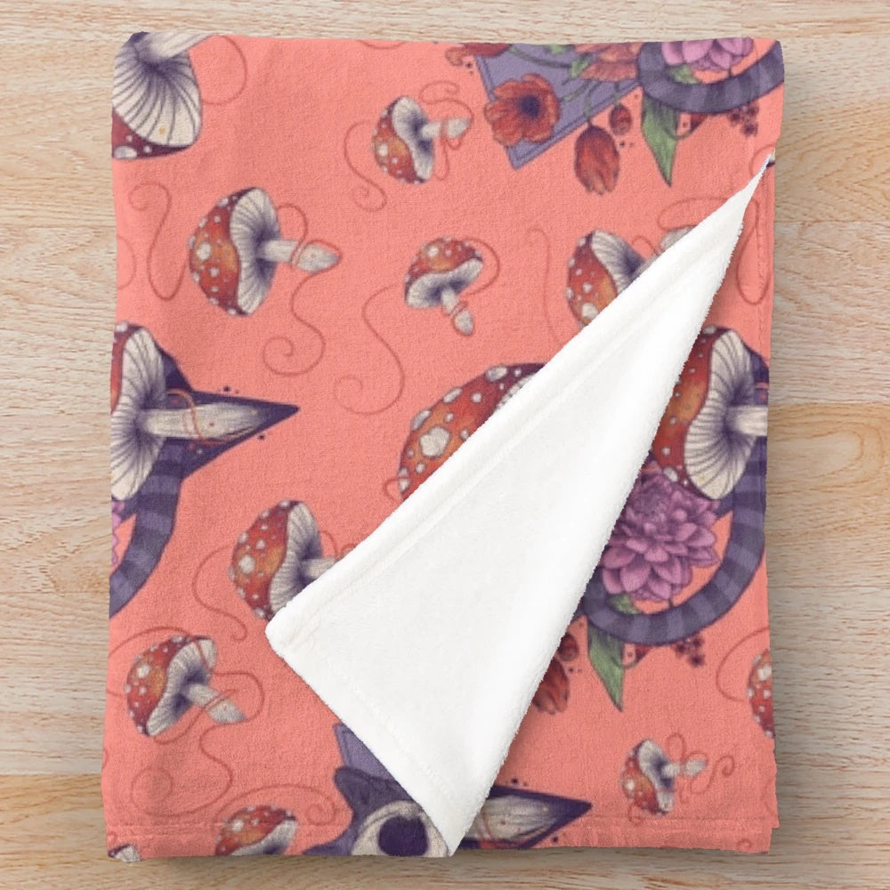 Colorful plush blanket featuring an Alice in Wonderland inspired design with a cat and flowers