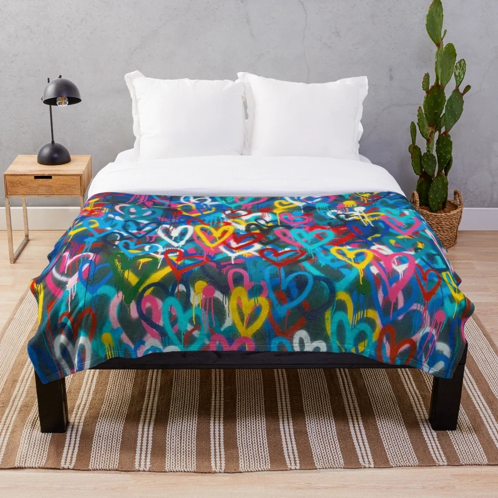 Plush blanket with abstract, colorful graffiti-style hearts and city wall pattern