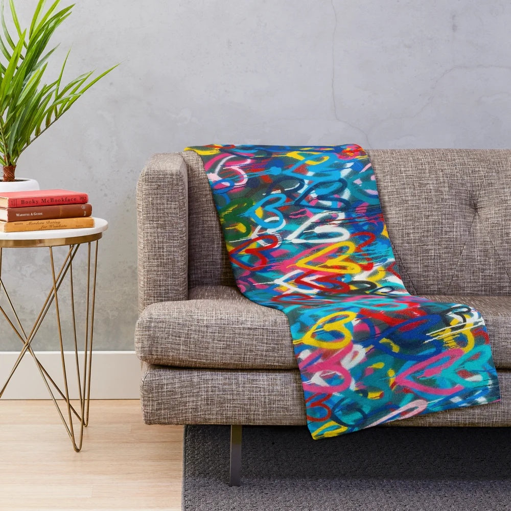 Plush blanket with abstract, colorful graffiti-style hearts and city wall pattern