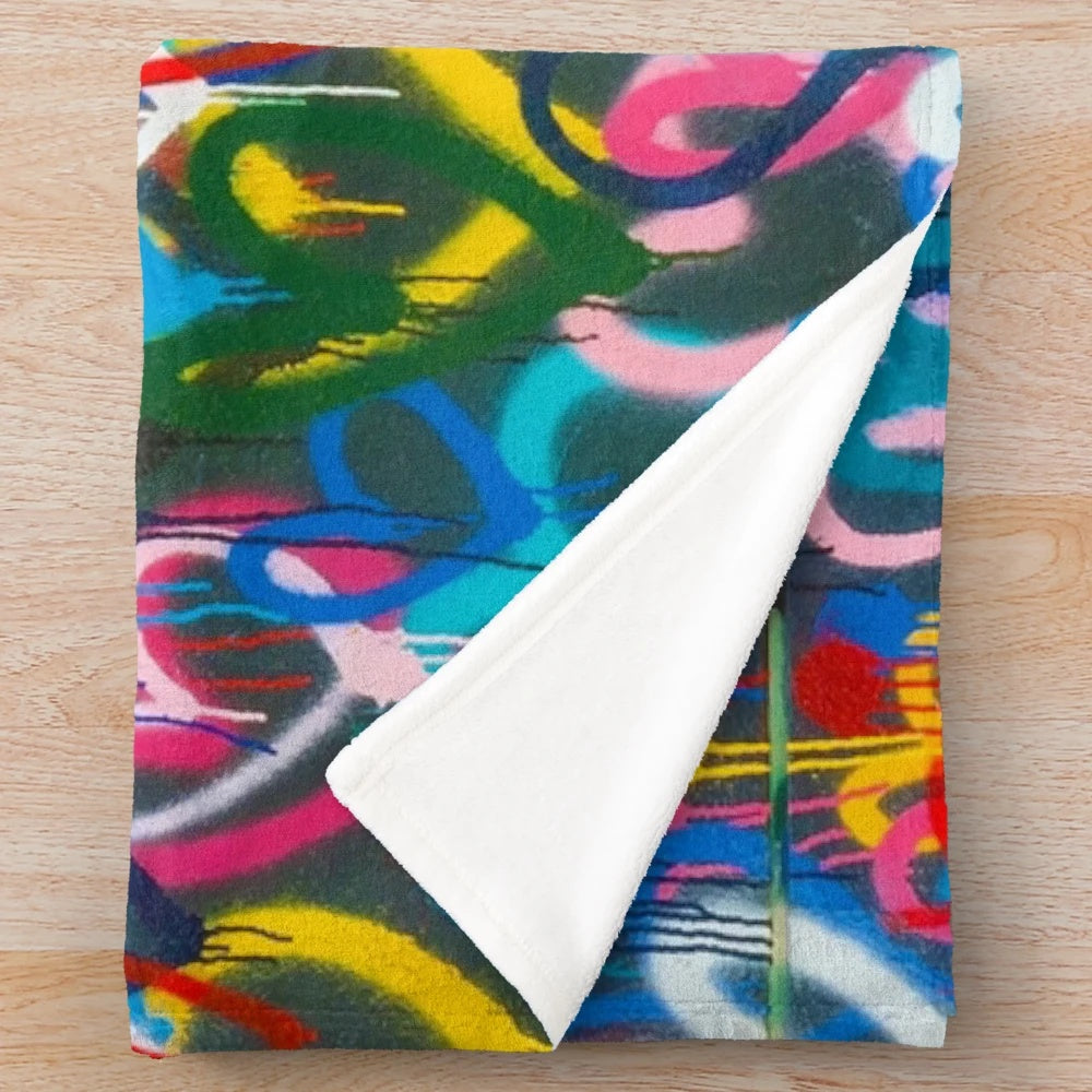 Plush blanket with abstract, colorful graffiti-style hearts and city wall pattern