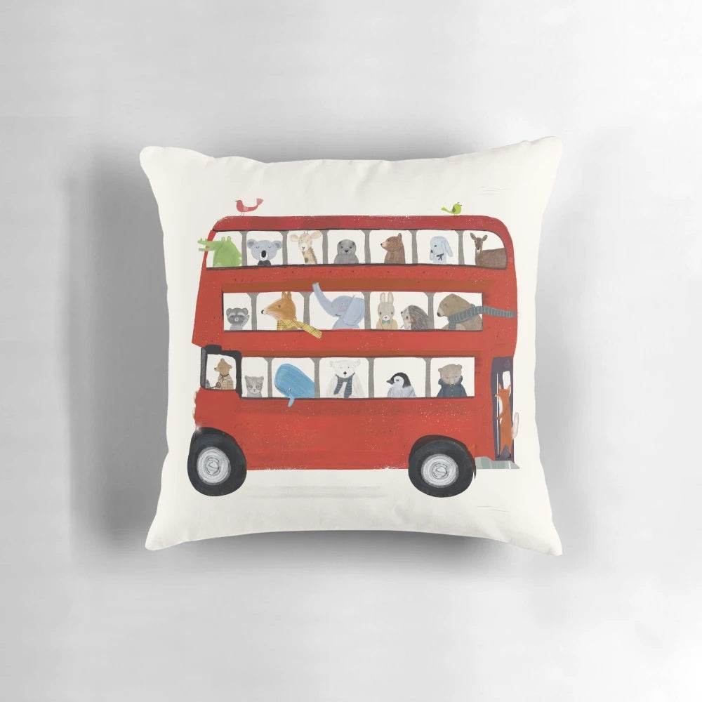 Vibrant illustration of a red London bus on a soft, decorative pillow for a nursery or child's room.