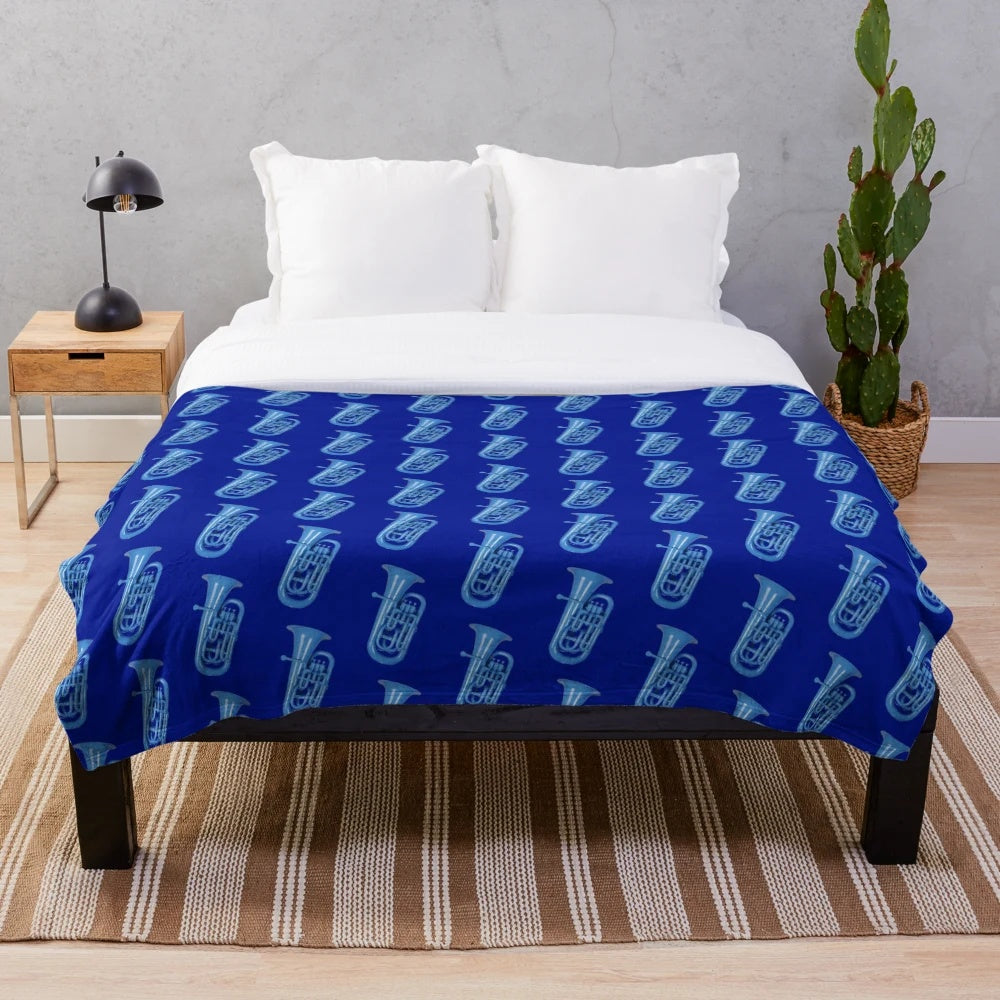 Blue plush blanket with musical instruments like baritone, euphonium, and tuba